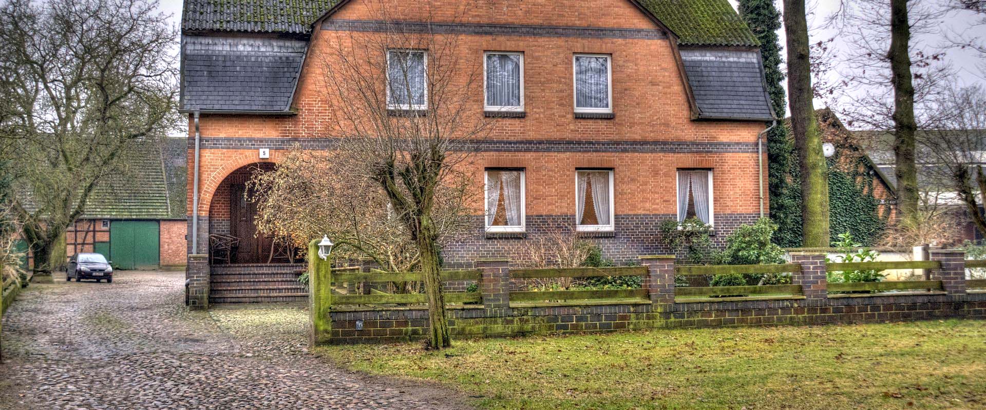 Bauernhaus mit Einfahrt und Zaun